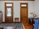 Office space with hardwood floors, featuring classic wood doors and trim with a view of a blue rug at 146 E Broadway St, Shelbyville, IN 46176