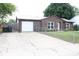 Cozy brick home featuring a metal roof, attached garage and chain link fence in front at 1504 Gwinn Ln, Lapel, IN 46051