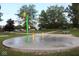 A splash pad with colorful buckets and fountains provides a fun water play area for children at 1504 Gwinn Ln, Lapel, IN 46051