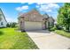 Inviting brick home showcases a two-car garage, mature landscaping, and a pristine front yard at 16130 Matlock Cir, Westfield, IN 46074