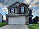 Two-story home featuring stone accents, a two-car garage, and a well-manicured front lawn at 19533 Chip Shot Rd, Noblesville, IN 46062
