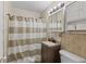 Tiled bathroom features vanity with granite countertop, shower, and toilet at 2017 E Legrande Ave, Indianapolis, IN 46203