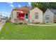 Bungalow with well-kept lawn, red porch swing, charming landscaping, and classic design at 2017 E Legrande Ave, Indianapolis, IN 46203