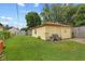 Exterior of the yellow detached garage and lawn area with bench and trash cans at 2017 E Legrande Ave, Indianapolis, IN 46203
