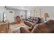 Comfortable living room with a brown leather sofa, chair, area rug, and plenty of natural light at 2017 E Legrande Ave, Indianapolis, IN 46203