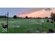 Scenic backyard with a lush green lawn, mature trees, and automated sprinkler system at sunset at 204 St Andrews Ave, Edinburgh, IN 46124