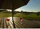 Scenic view of a lush golf course with sprinklers, enjoyed from a table with wine glasses, promising a relaxing lifestyle at 204 St Andrews Ave, Edinburgh, IN 46124
