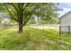 Fenced backyard with a mature tree and grassy areas perfect for outdoor activities at 2443 S Brandywine Ct, Greenfield, IN 46140