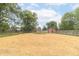 Fenced backyard features straw, a shed, and mature trees, offering privacy and space at 2443 S Brandywine Ct, Greenfield, IN 46140