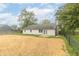 Exterior view of the home revealing a spacious backyard with straw and a fence at 2443 S Brandywine Ct, Greenfield, IN 46140