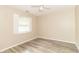 Bright bedroom with neutral walls, hardwood floors, ceiling fan, and window with white trim at 2443 S Brandywine Ct, Greenfield, IN 46140