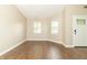Cozy living room with two windows and light-colored walls, leading to the front door at 2443 S Brandywine Ct, Greenfield, IN 46140