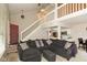 Open-concept living area featuring a large sectional sofa, staircase, and adjacent kitchen at 2578 Chaseway Ct, Indianapolis, IN 46268