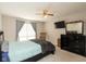 This main bedroom features a ceiling fan, large window, and a TV at 2578 Chaseway Ct, Indianapolis, IN 46268