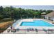 A community pool is surrounded by lounge chairs and overlooks a beautiful lake at 2578 Chaseway Ct, Indianapolis, IN 46268