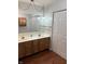 Bathroom featuring double sinks, wood cabinets, large mirror, and closet with white doors at 2770 Two Worlds Dr, Columbus, IN 47201