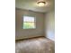 Neutral bedroom with carpet flooring, single window with backyard views and wall fixture light at 2770 Two Worlds Dr, Columbus, IN 47201