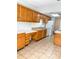 Functional kitchen with warm-toned cabinets, tile floor, and a full appliance suite at 2770 Two Worlds Dr, Columbus, IN 47201
