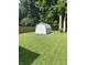 Lush green backyard featuring a shed surrounded by mature trees and a privacy fence at 2822 Tindall St, Indianapolis, IN 46203