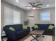 Comfortable living room with two navy blue sofas, green pillows, a ceiling fan, and natural light at 2822 Tindall St, Indianapolis, IN 46203