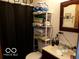 Compact bathroom with a toilet, sink, mirror, and shower curtain, providing basic amenities at 3213 S Cherokee Rd, Muncie, IN 47302