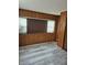 A cozy living room includes wood paneling, updated flooring, and windows offering natural light at 3216 Memorial N Dr, Elwood, IN 46036