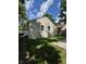 Backyard showcasing home with siding, green grass, an air conditioning unit and gravel area at 3711 Hillside Ave, Indianapolis, IN 46218