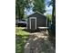 Backyard shed surrounded by trees, features great storage with an exterior door and practical design at 3711 Hillside Ave, Indianapolis, IN 46218