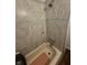 Close-up of shower with marble-patterned tile and a decorative glass tile accent stripe at 3711 Hillside Ave, Indianapolis, IN 46218