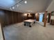 Spacious basement with carpeted floor, wood paneled wall, and pool table at 4675 N Riverside Dr, Columbus, IN 47203