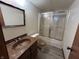 Bathroom with a tub and shower combo, framed mirror, and brown marble-style sink at 4675 N Riverside Dr, Columbus, IN 47203