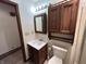 Bathroom featuring a sink and cabinet, toilet, mirror, and light fixture, and wood-look flooring at 4675 N Riverside Dr, Columbus, IN 47203