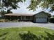 Charming brick ranch home with a well-maintained lawn, mature landscaping, and a two car garage at 4675 N Riverside Dr, Columbus, IN 47203