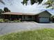 Charming brick ranch home with a well-maintained lawn, mature landscaping, and a two car garage at 4675 N Riverside Dr, Columbus, IN 47203