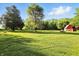 Large grassy backyard with a red barn, mature trees, and open space at 4765 E 200 N, Anderson, IN 46012