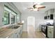The kitchen offers a gas range oven, microwave, double sink, and open door in an open-concept floor plan at 4765 E 200 N, Anderson, IN 46012