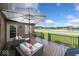 Inviting back porch featuring an umbrella, outdoor seating and scenic views of the community pond at 4909 N Graystone Dr, Muncie, IN 47304