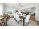 Dining room featuring tray ceiling, hardwood floors, bright windows, and dining table at 4909 N Graystone Dr, Muncie, IN 47304