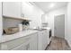 Bright laundry room featuring white cabinets, modern appliances, and granite countertops at 4909 N Graystone Dr, Muncie, IN 47304