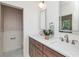Bathroom featuring double sink vanity with marble countertops and a view to the backyard at 5930 Broadway St, Indianapolis, IN 46220
