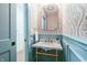Half bath boasts patterned wallpaper, light blue wainscoting, and a marble sink at 5930 Broadway St, Indianapolis, IN 46220