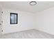 A clean, well-lit bedroom features neutral carpet, a window, and minimalist design elements at 5930 Broadway St, Indianapolis, IN 46220