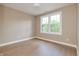 An empty bedroom featuring hardwood floors and a large window with a view of lush greenery at 5930 Broadway St, Indianapolis, IN 46220