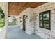 Charming front porch featuring whitewashed brick, wood ceiling, and stylish lighting fixtures at 5930 Broadway St, Indianapolis, IN 46220