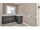 Well-lit laundry area with custom cabinets, sink, marble countertop, and stylish patterned floors at 5930 Broadway St, Indianapolis, IN 46220