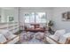 Bright living room features a brown leather couch, bookshelves, and a large window at 5930 Broadway St, Indianapolis, IN 46220