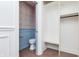 Mudroom connects to an adjacent half bath with patterned wallpaper and light blue wainscoting at 5930 Broadway St, Indianapolis, IN 46220