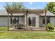 Backyard view of a pergola-covered patio with a table and chairs, leading to a sliding glass door at 6102 Boulder Dr, Anderson, IN 46013