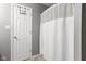 Clean bathroom featuring a door with coat hooks and a shower with a white, textured curtain at 6102 Boulder Dr, Anderson, IN 46013