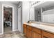 Bathroom with a wood vanity, large mirror, and well-organized closet and shelving at 6102 Boulder Dr, Anderson, IN 46013